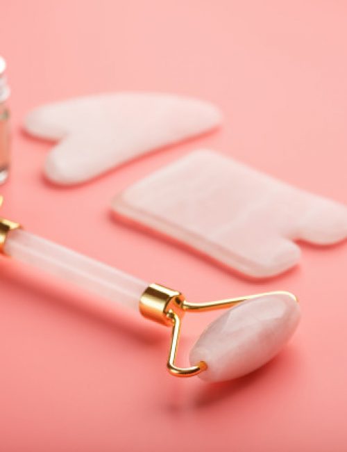 gua-sha-massage-tool-made-natural-pink-quartz-roller-jade-stone-oil-pink-background-face-body-care-part-traditional-chinese-medicine_94046-4160